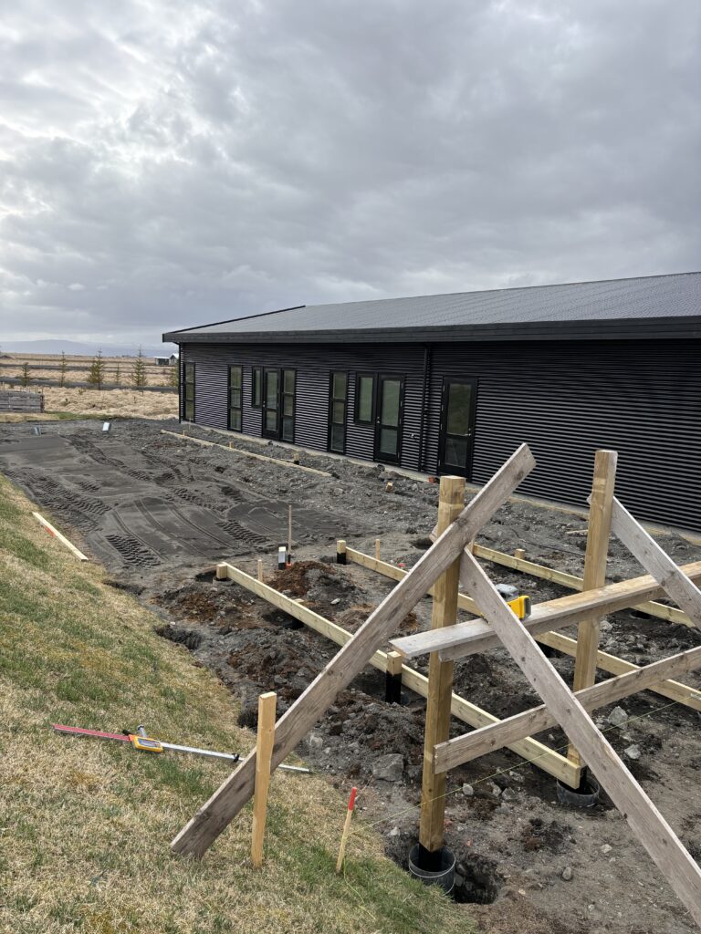 Yfirlitsmynd af útisvæðinu í Byggðarhorni þegar búið er að slá upp pallagrind og skjólveggjastaurum