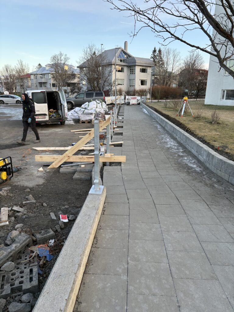Stífur á járnstaura fyrir skjólvegg í skógarhlíð