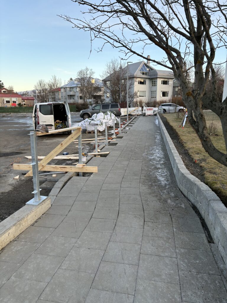 Komið fyrir undirstöðum að grindverki í reykjavík