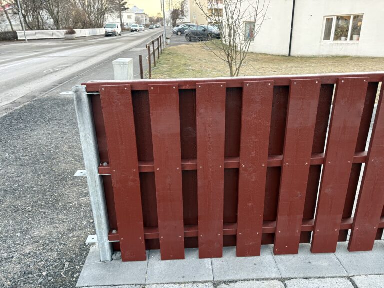 Grindverk klætt beggja vegna skógarhlíð