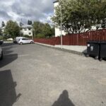 Yfirlit af fullkláruðu grindverki fyrir Reykjavíkurbor af grindverki við Skógarhlíð séð úr porti í Eskihlíð